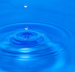 Naklejka na ściany i meble a drop of water falling in blue water. macro