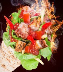 Chicken slices in a Tortilla with fire.