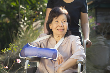 Asian senior woman with broken wrist on wheel chair