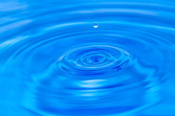 Naklejka na ściany i meble kropla wody spada na niebiesko wody. makro