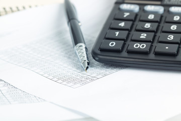 calculator and pen with financial documents