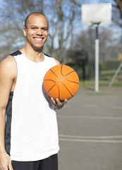 Portrait of a male basketball player on an outdoor court