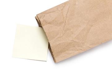 Note paper in Brown paper bag on a White Background