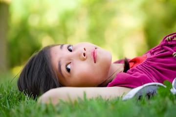 Little girl lying on grass