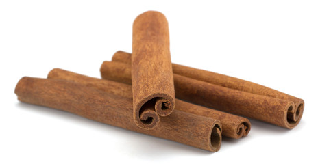 cinnamon sticks stacked on white background