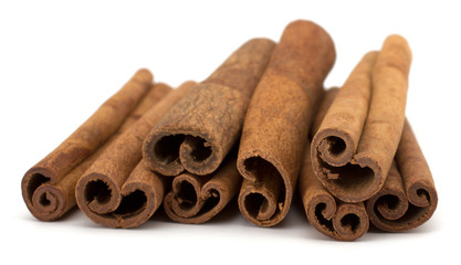 cinnamon sticks stacked on white background