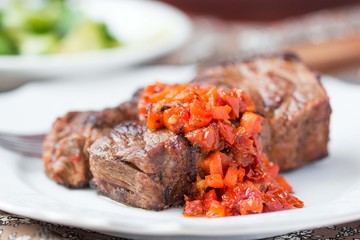 Grilled beef steak with salsa sauce dried tomatoes, red peppers