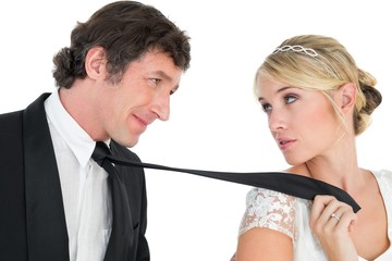 Bride pulling tie of groom