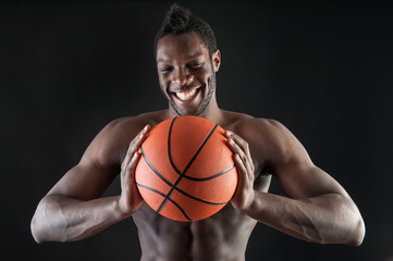 Portrait of smiling young black man shirtless with basket ball a