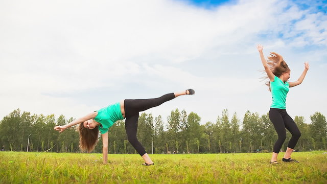 Young Woman Tumbling Wheel, acrobatics on a green glade