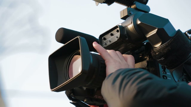Man filming outdoors with a professional camera