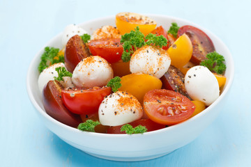 bowl of salad with mozzarella, fresh herbs and cherry tomatoes