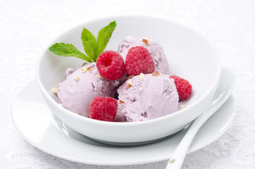 ice cream with fresh raspberries and mint in a bowl