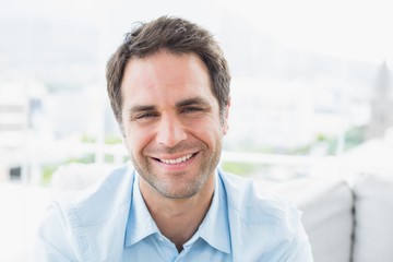 Happy man sitting on the couch smiling at camera