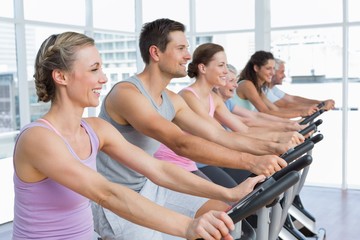 Fototapeta premium Happy people working out at spinning class
