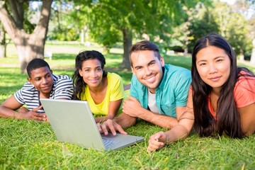 Smiling students with laptop on campus