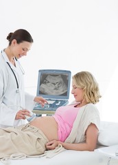 Obraz premium Doctor performing ultrasound on pregnant woman