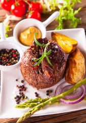 Delicious beef steaks with fresh vegetable and trimmings on wood