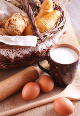 Still life with fresh pastries and a cup of milk