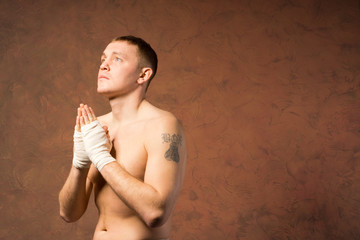 Young boxer praying before a match