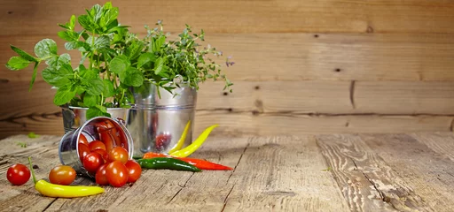Photo sur Plexiglas Herbes Tomatoes, chives and chili peppers on a wooden table top