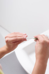 Junge Frau feilt ihre Fingernägel