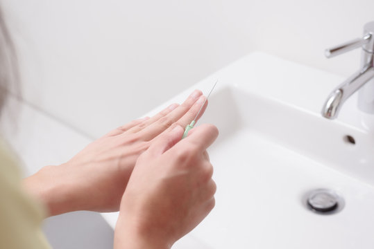 Junge Frau feilt ihre Fingern&auml;gel