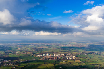 Fototapeta na wymiar Aerial view of small town and green fields through plane window