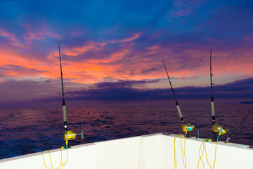 boat fishing trolling at sunset with rods and reels