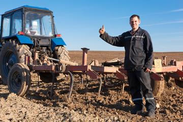 Obraz premium Farmer man standing in cultivated field and showing OK gesture