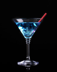 Blue cocktail in martini glass isolated on black