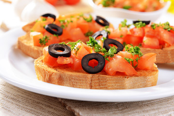 Delicious bruschetta with tomatoes on plate on table close-up