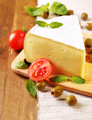 Tasty Camembert cheese with tomatoes, olives and basil,