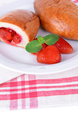 Fresh baked pasties with strawberries on plate on table
