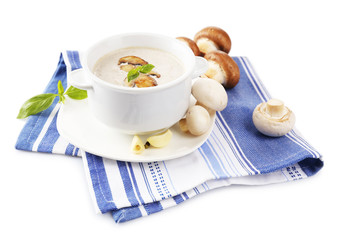Mushroom soup in white pot, on napkin, isolated on white