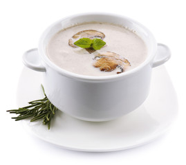 Mushroom soup in white bowl, on plate, isolated on white