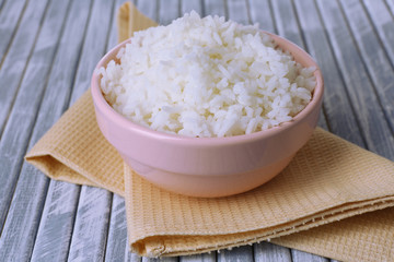 Cooked rice in bowl on wooden background