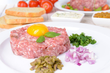 Fototapeta premium Delicious steak tartare with yolk on plate on table close-up