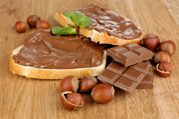 Bread with sweet chocolate hazelnut spread on wooden background