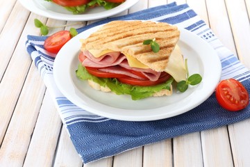 Tasty sandwich with ham on wooden table