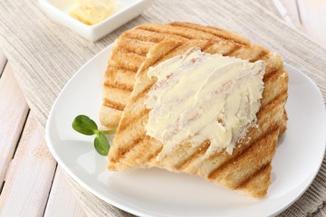 Grilled bread with butter on wooden table