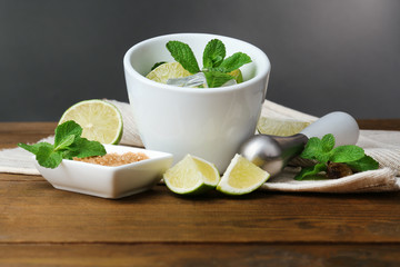 Ingredients for lemonade on wooden table, on grey background