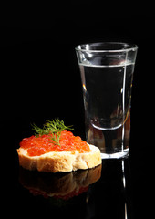 Sandwich with caviar and vodka isolated on black