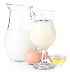 Eggnog with milk and eggs isolated on white