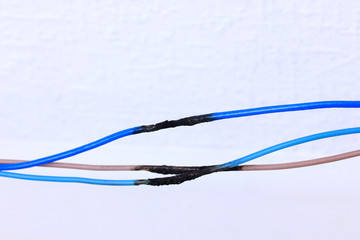 Short circuit, burnt cable, on color wooden background