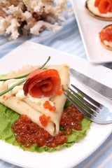 Pancakes with red caviar, salmon and mayo, green onion,
