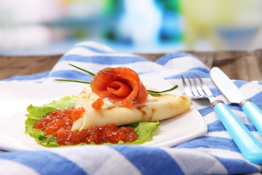 Pancake with red caviar, salmon and mayo, green onion,