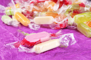 Tasty candies on purple background