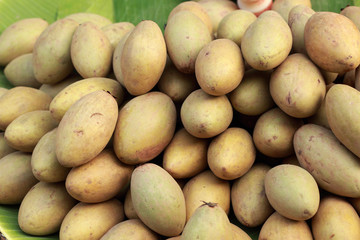 Sapodilla fruit pile in the background.