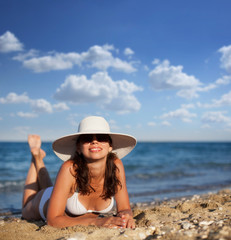 Young woman sunbathes at the seaside.